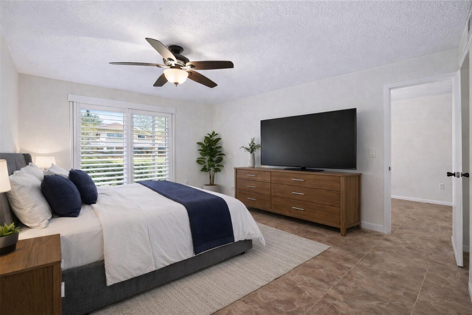 717 Highway 1, Unit 305 Jupiter, FL 33477 - Photo 10 of 51 a bedroom with a bed and a flat screen tv