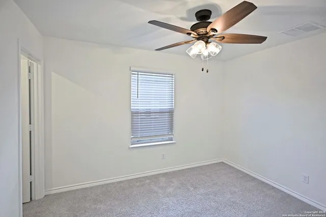 a view of a livingroom with a chandelier fan and a window