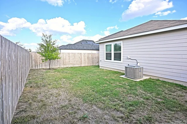 a view of a backyard with wooden fence