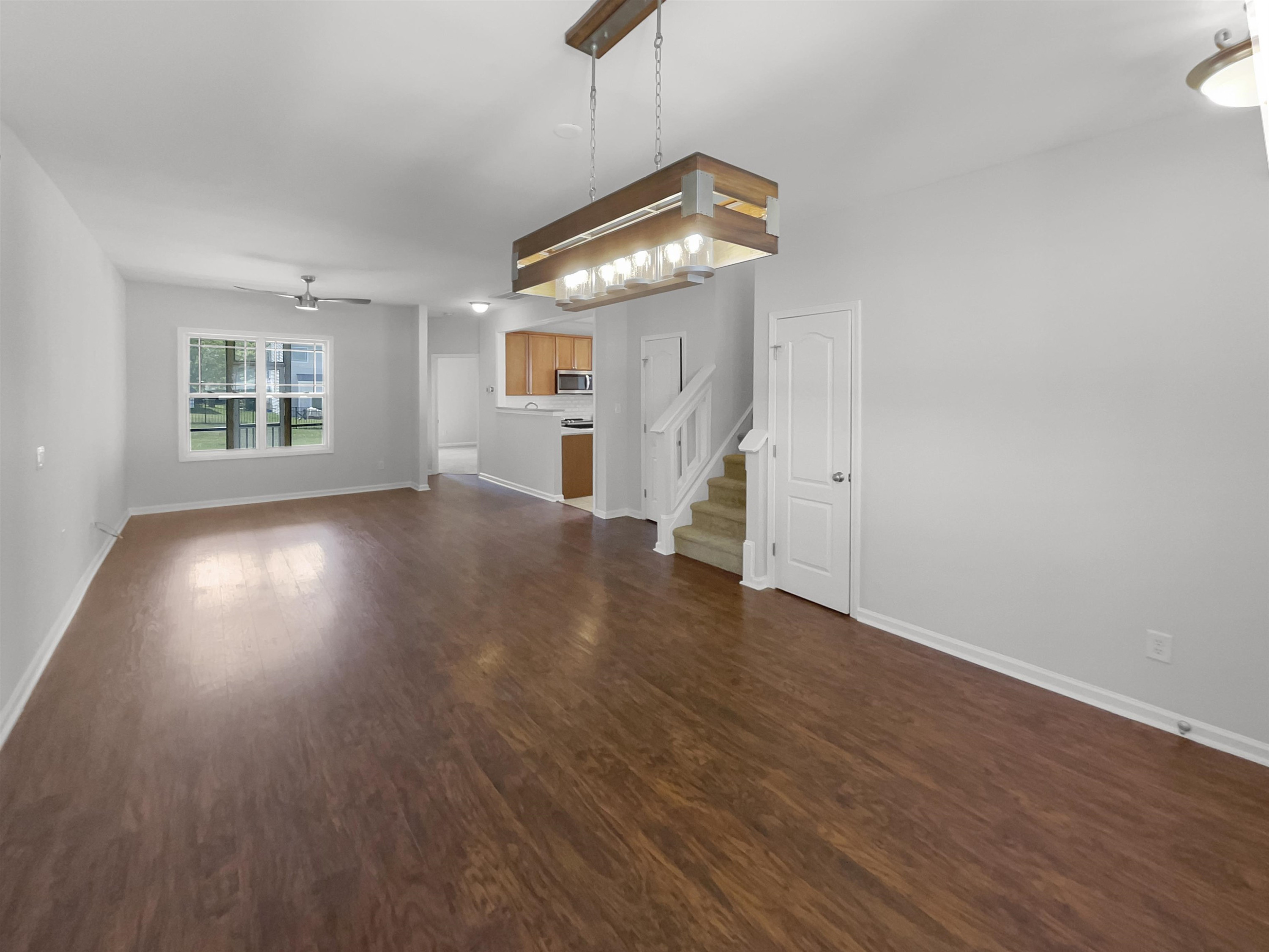 3154 Groveshire Drive Raleigh, NC 27616 - Photo 7 of 20 an empty room with wooden floor chandelier and windows