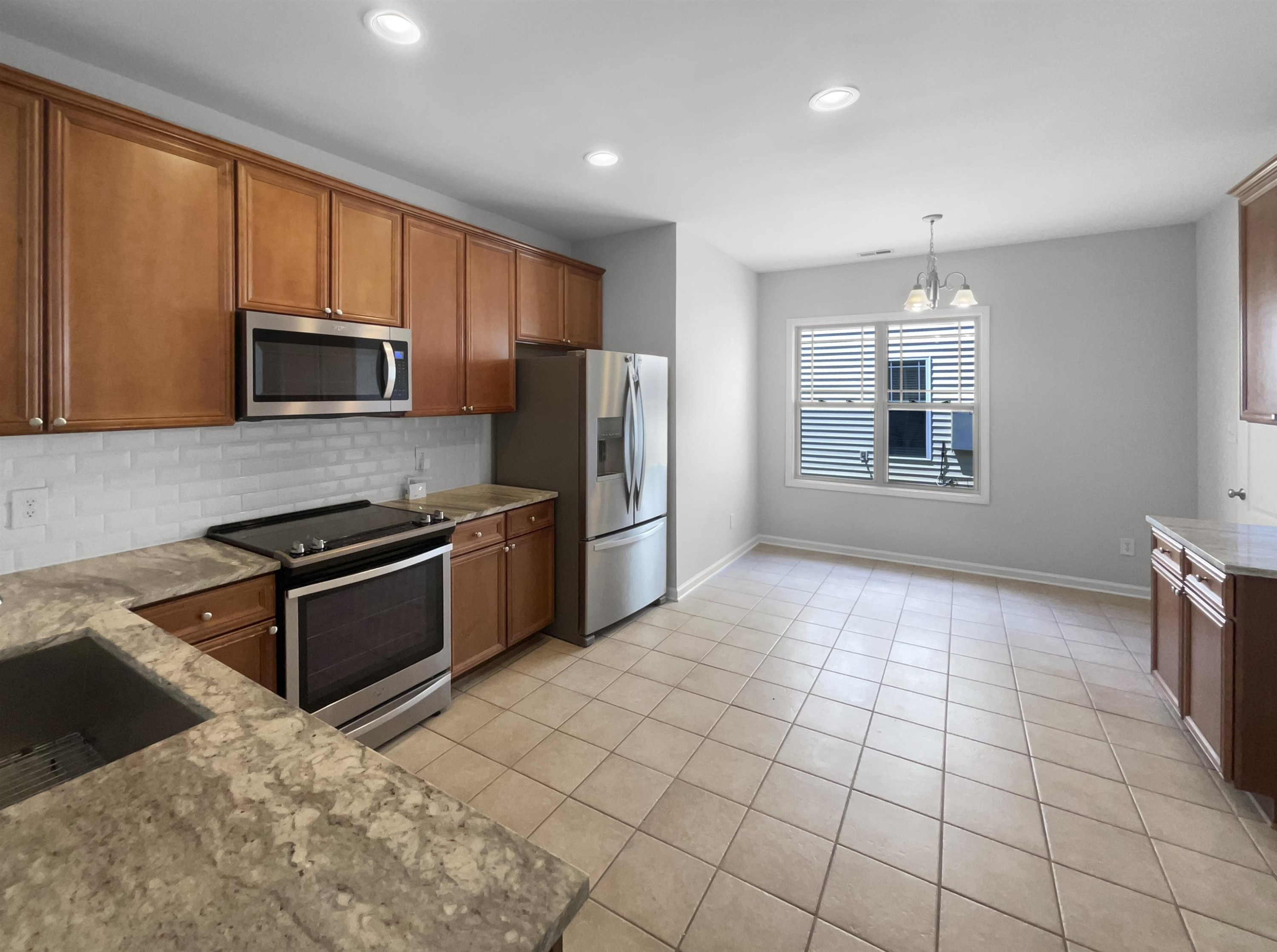 3154 Groveshire Drive Raleigh, NC 27616 - Photo 8 of 20 a kitchen with stainless steel appliances granite countertop a stove a sink and a microwave