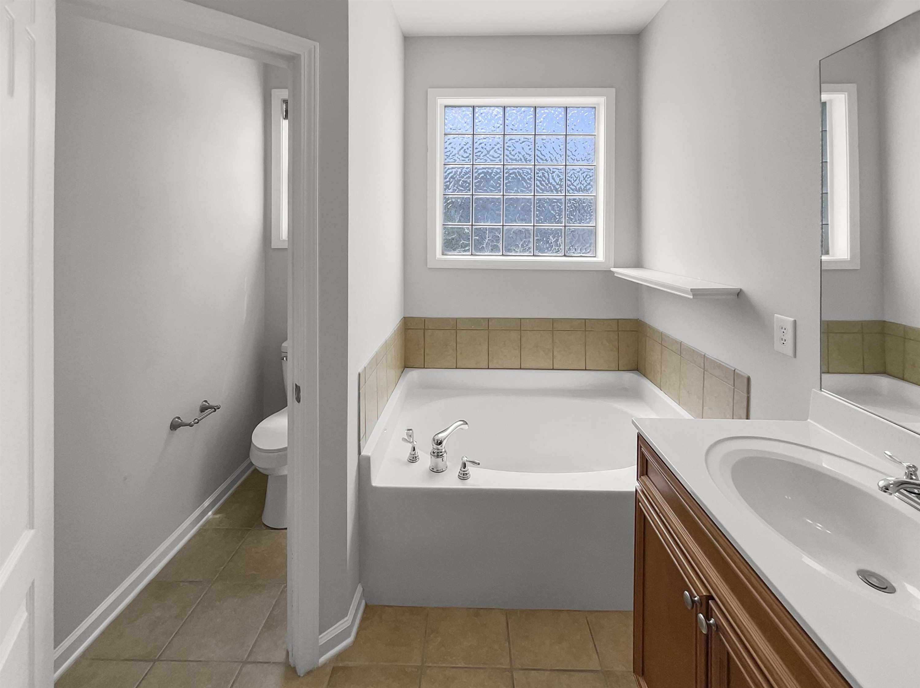 3154 Groveshire Drive Raleigh, NC 27616 - Photo 10 of 20 a bathroom with a sink a bathtub and a window