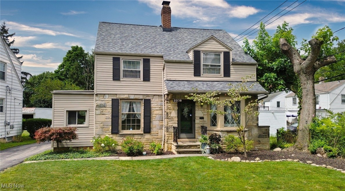 2278 Traymore Road Cleveland, OH 44118 - Photo 1 of 49 View of front of home featuring a shingled roof, a front lawn, stone siding, and a chimney