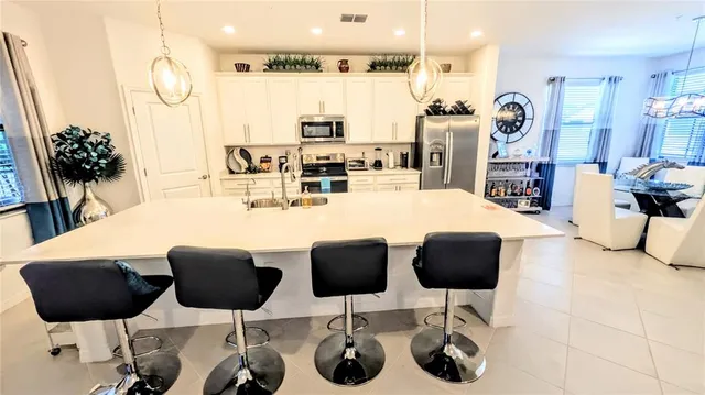 a kitchen with stainless steel appliances kitchen island granite countertop a table and chairs