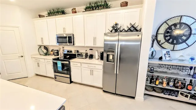 a kitchen with white cabinets and white appliances