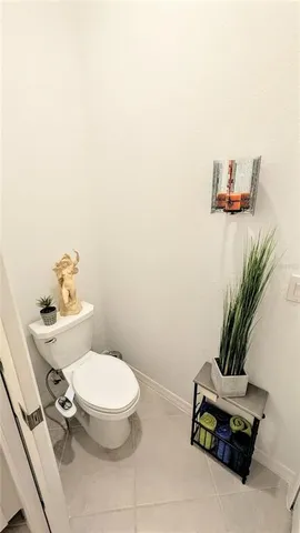a bathroom with a toilet and a potted plant