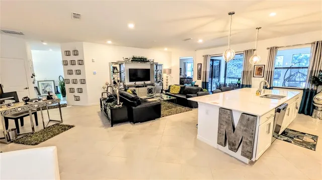 a living room with furniture a flat screen tv and a large window