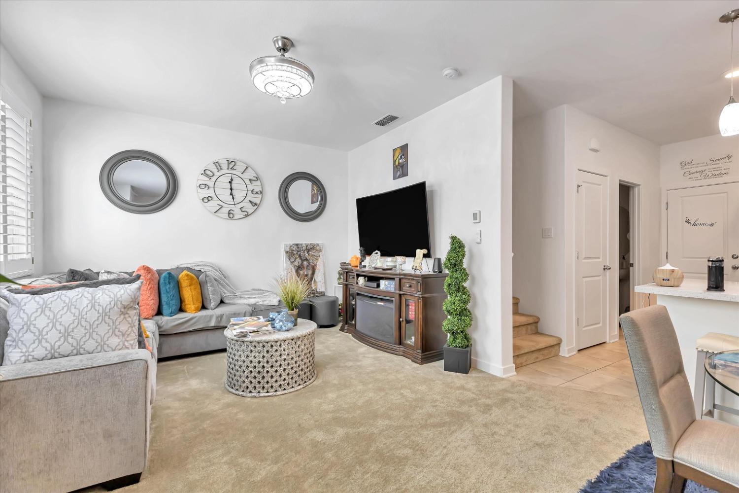 a living room with furniture a flat screen tv and a clock