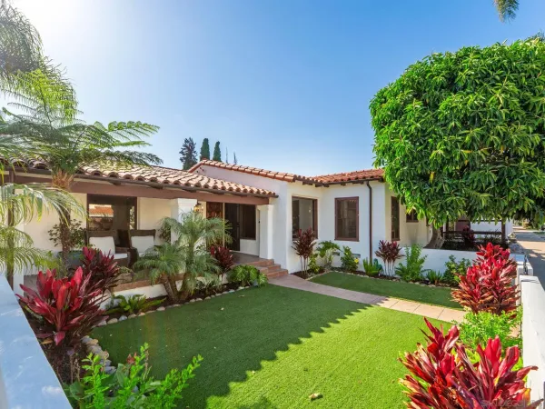 a front view of house and yard with seating and green space