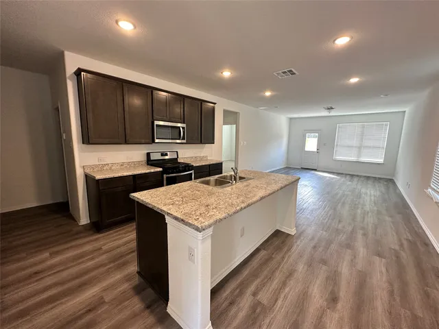 a kitchen with kitchen island sink stove and refrigerator