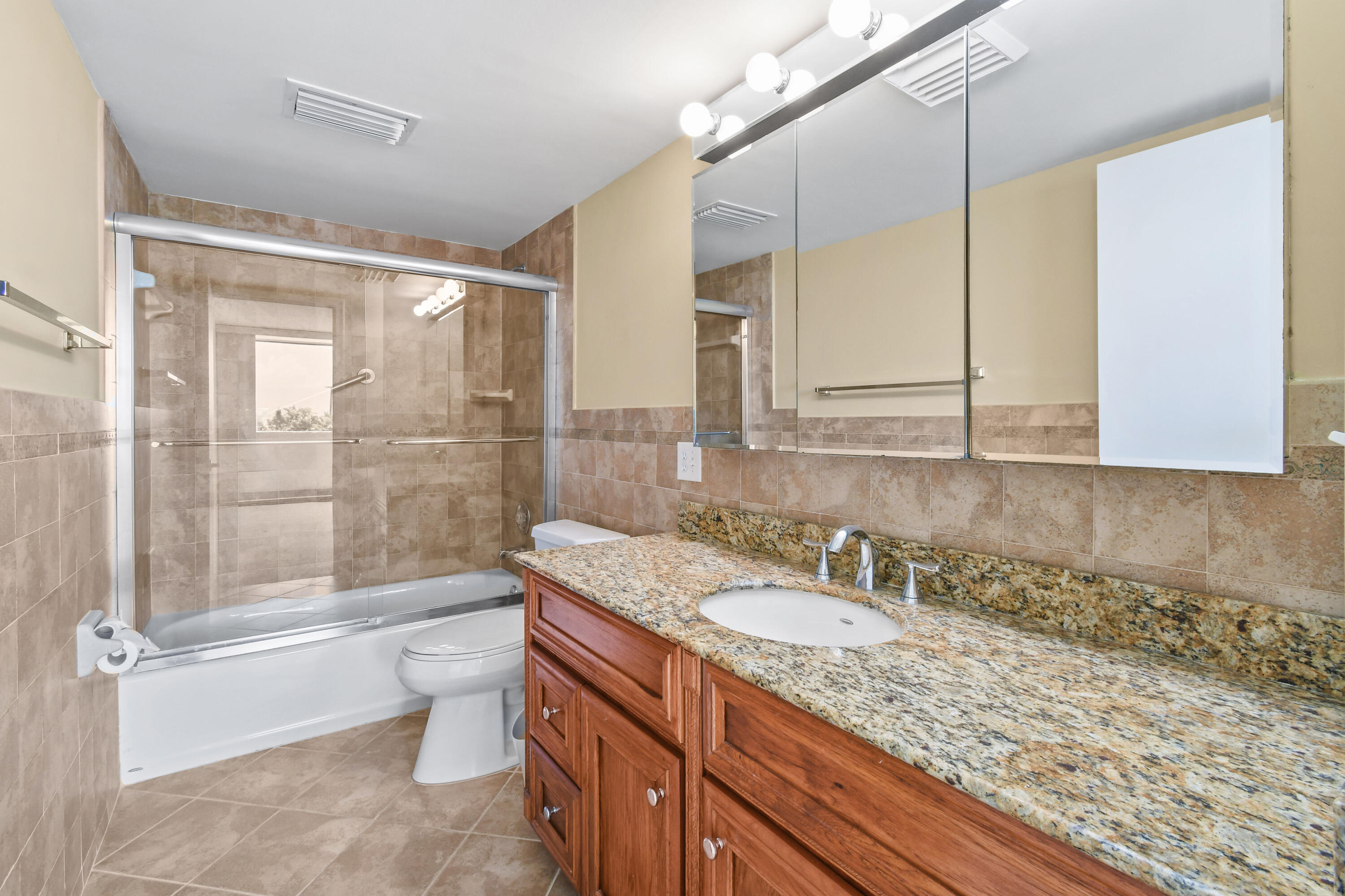 5200 North Flagler Drive, Unit 404 West Palm Beach, FL 33407 - Photo 15 of 33 a bathroom with a granite countertop sink a toilet and shower
