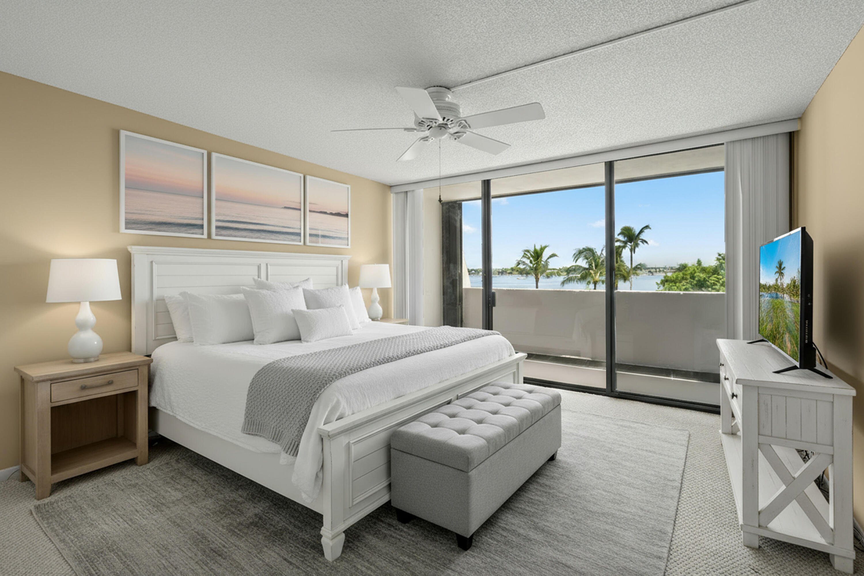 5200 North Flagler Drive, Unit 404 West Palm Beach, FL 33407 - Photo 18 of 33 a bedroom with a bed flat screen tv and a large window