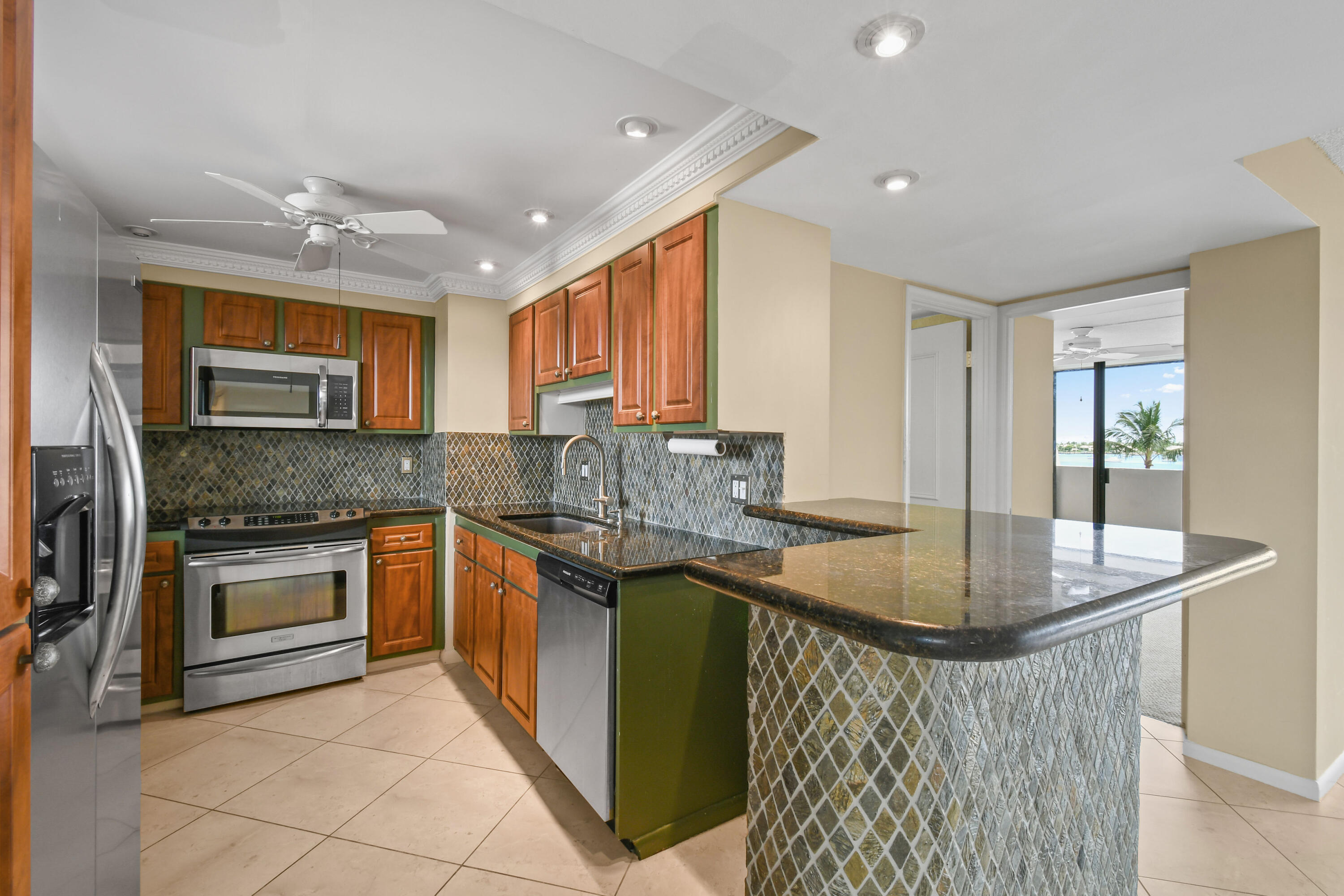 5200 North Flagler Drive, Unit 404 West Palm Beach, FL 33407 - Photo 9 of 33 a kitchen with stainless steel appliances granite countertop a sink stove and refrigerator