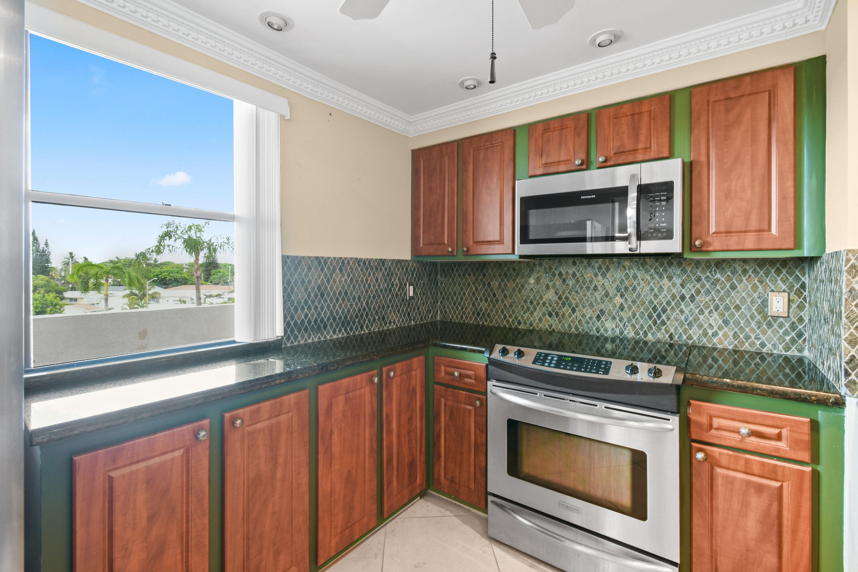 5200 North Flagler Drive, Unit 404 West Palm Beach, FL 33407 - Photo 10 of 33 a kitchen with stainless steel appliances granite countertop a stove microwave and cabinets