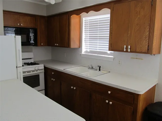 a kitchen with a sink cabinets stainless steel appliances and a window