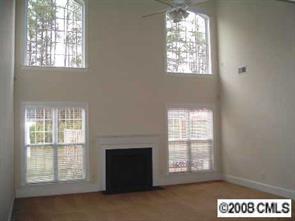 2423 Blueberry Ridge Road Matthews, NC 28105 - Photo 3 of 8 an empty room with a fireplace and windows