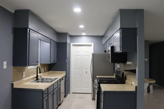 a kitchen with a sink stove and refrigerator