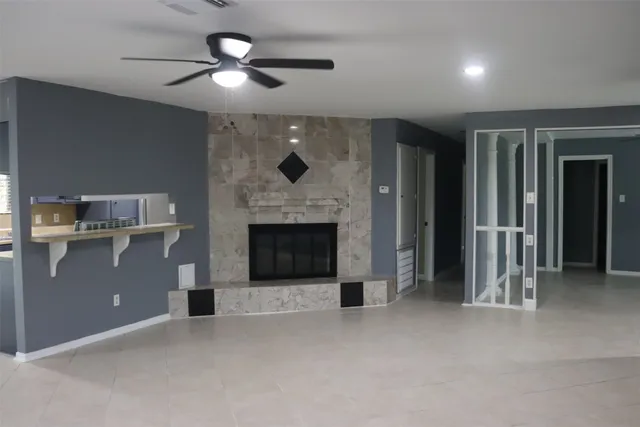 an empty room with windows and fireplace