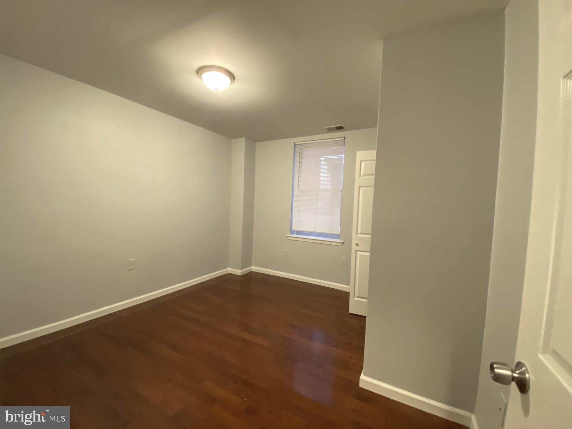4945 Chestnut Street Philadelphia, PA 19139 - Photo 19 of 27 an empty room with wooden floor and windows
