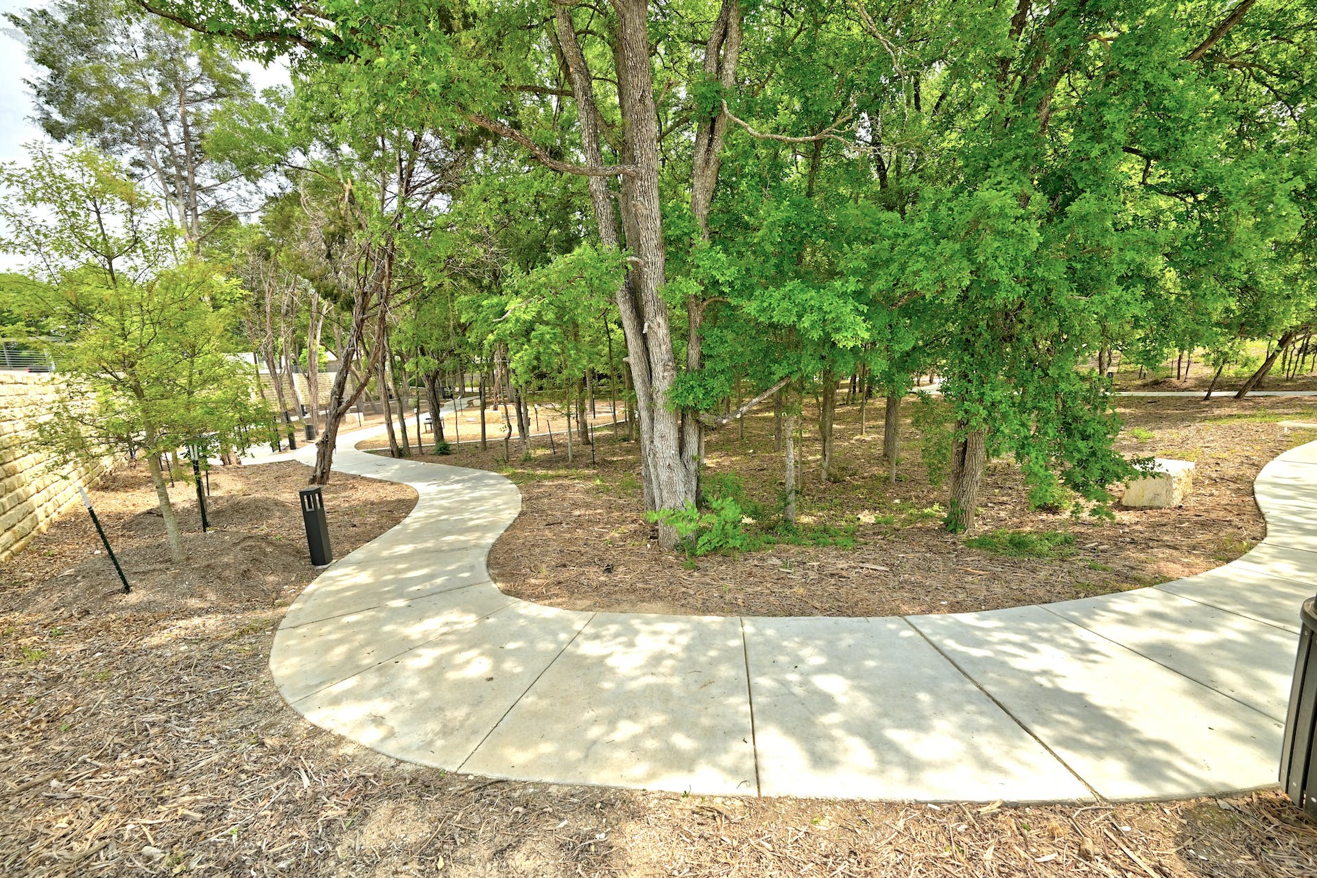 4801 Springdale Road, Unit 1301 Austin, TX 78723 - Photo 39 of 39 Winding pathways meander through a verdant landscape, perfect for leisurely strolls amidst mature trees.