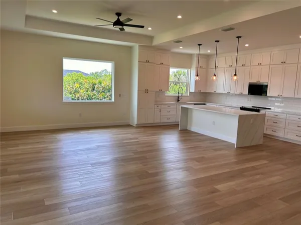 a large kitchen with cabinets wooden floor and a stainless steel appliances