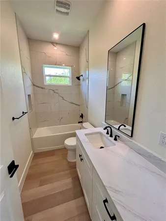 a bathroom with a double vanity sink a toilet a mirror and shower