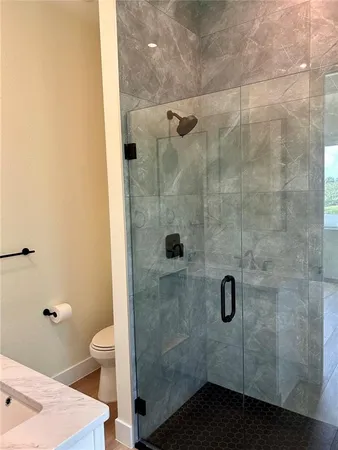 a bathroom with a shower a toilet and a sink