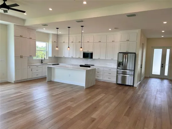a kitchen with granite countertop a refrigerator and a stove top oven
