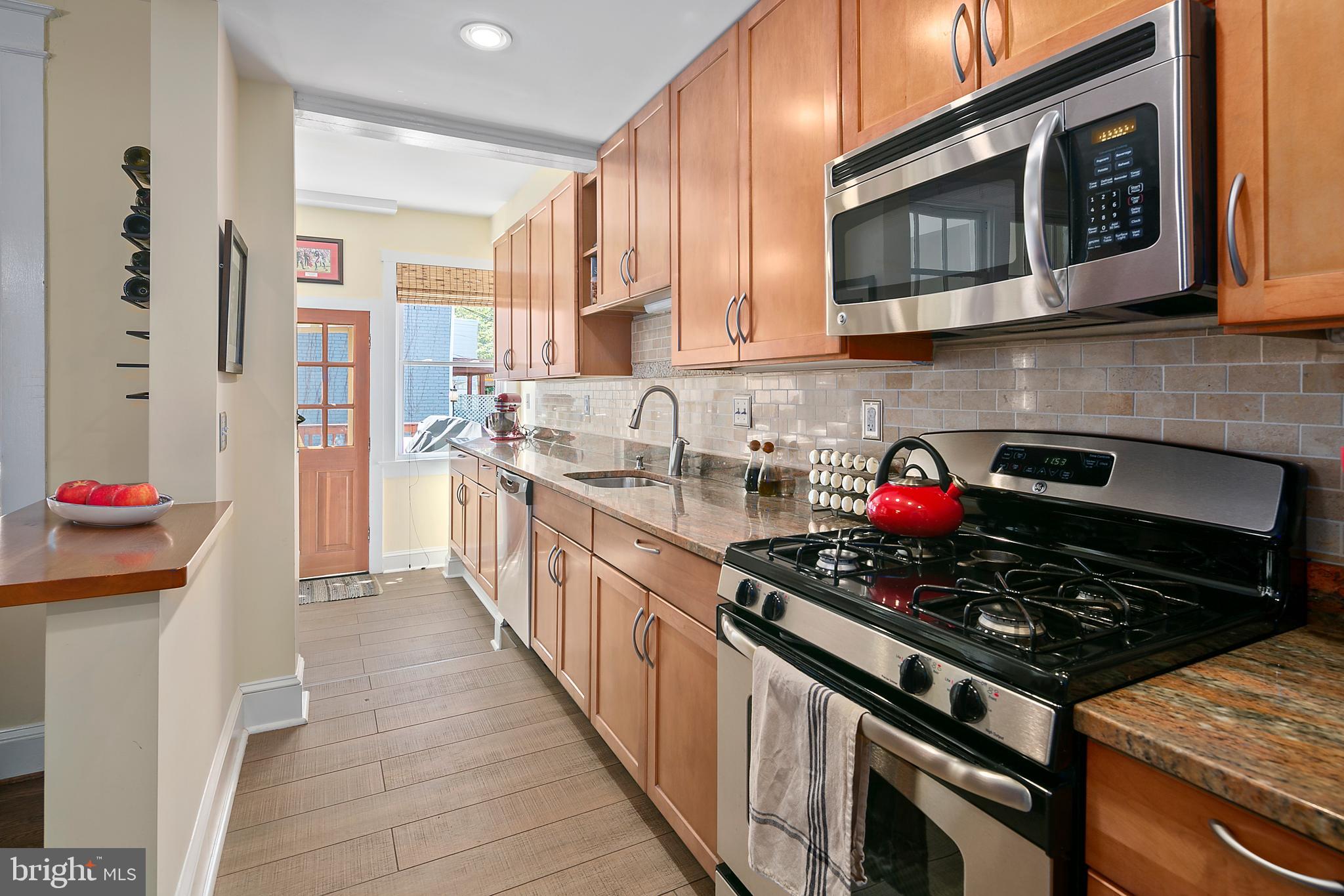 925 K Street Northeast Washington, DC 20002 - Photo 12 of 35 a kitchen with stainless steel appliances granite countertop a stove and cabinets