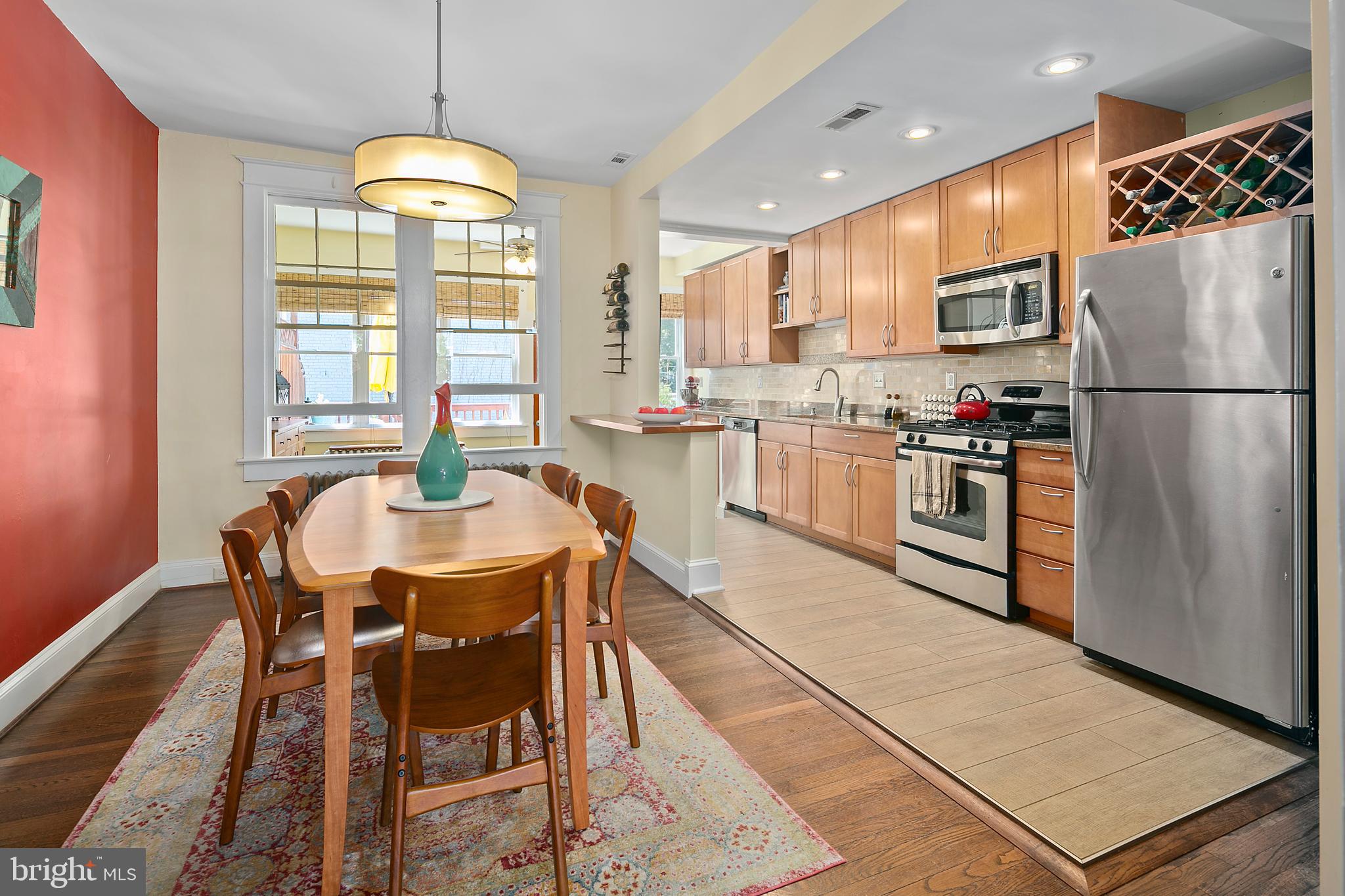 925 K Street Northeast Washington, DC 20002 - Photo 9 of 35 a kitchen with stainless steel appliances granite countertop a stove a refrigerator a kitchen island a stove and a dining table with wooden floor