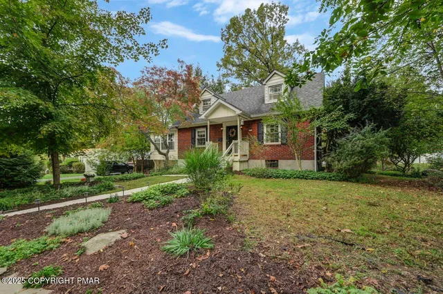a front view of a house with a yard and trees