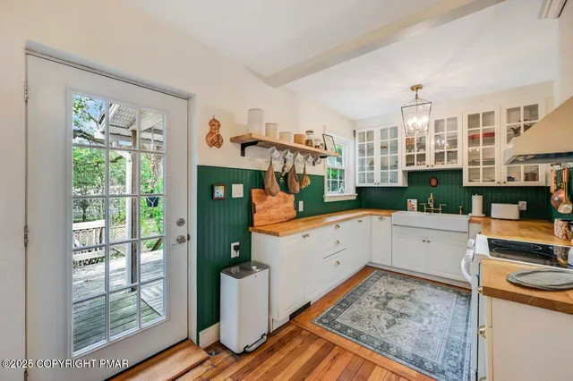 a kitchen with stainless steel appliances wooden floor and large window