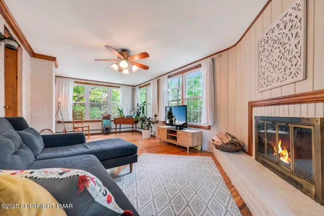 a living room with furniture a fireplace and a large window