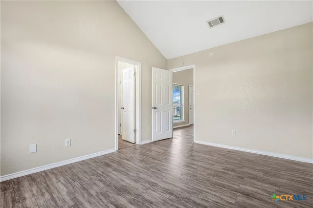 a view of an empty room with wooden floor