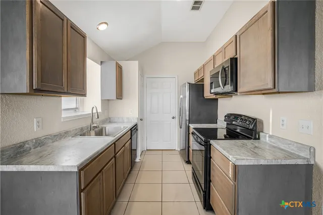 a kitchen with stainless steel appliances granite countertop a sink and a stove