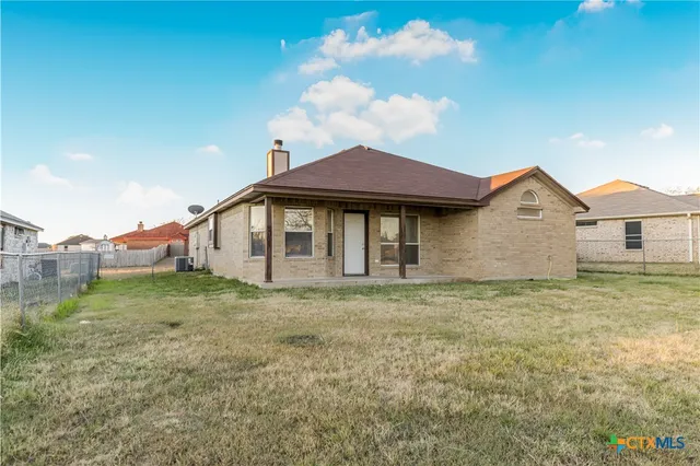 a view of a yard in front of a house with a large tree