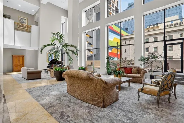 a living room with furniture fireplace and floor to ceiling windows