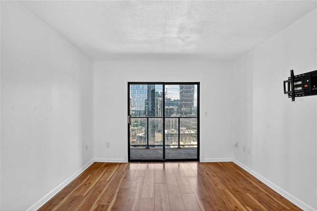 1280 West Peachtree Street Northwest, Unit 3014 Atlanta, GA 30309 - Photo 11 of 33 wooden floor in an empty room with a window