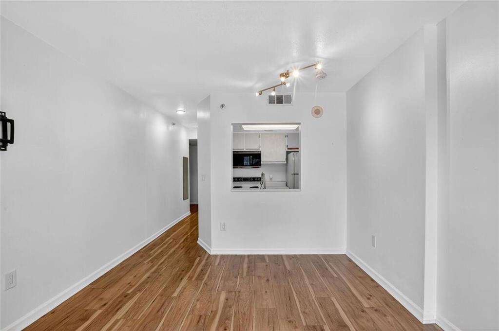 1280 West Peachtree Street Northwest, Unit 3014 Atlanta, GA 30309 - Photo 6 of 33 a view of a hallway with wooden floor and a refrigerator