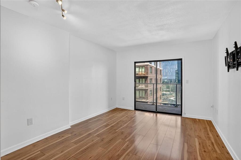 1280 West Peachtree Street Northwest, Unit 3014 Atlanta, GA 30309 - Photo 7 of 33 a view of an empty room with wooden floor and a window