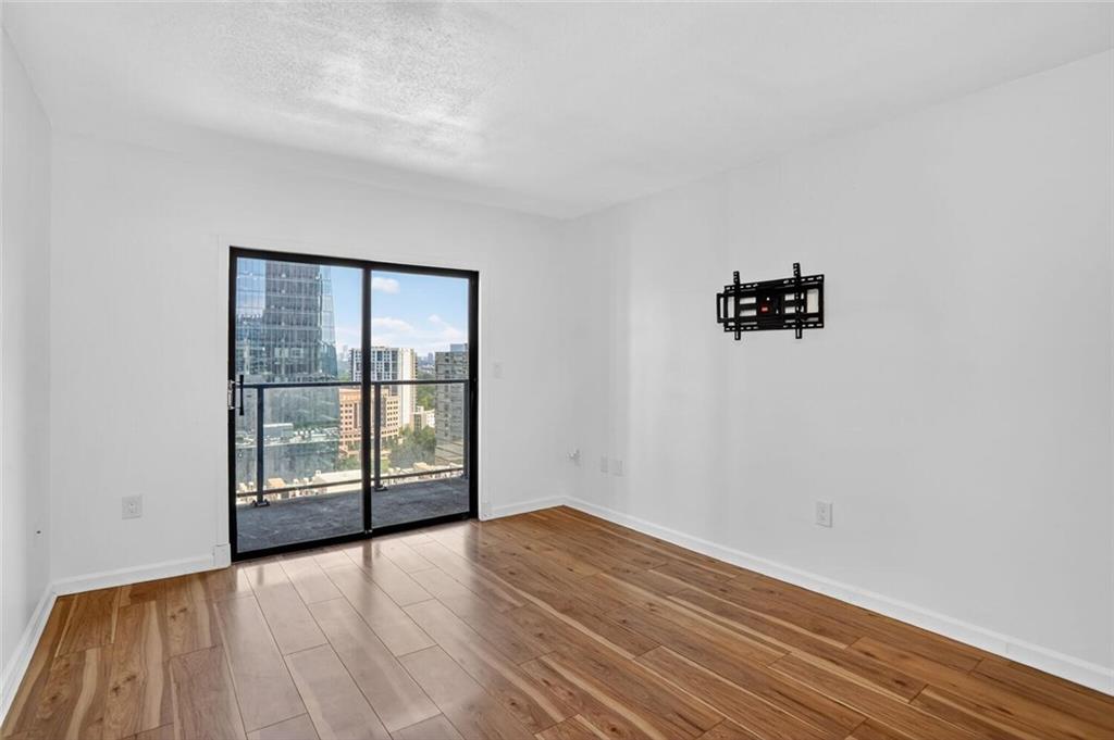 1280 West Peachtree Street Northwest, Unit 3014 Atlanta, GA 30309 - Photo 8 of 33 an empty room with wooden floor and windows