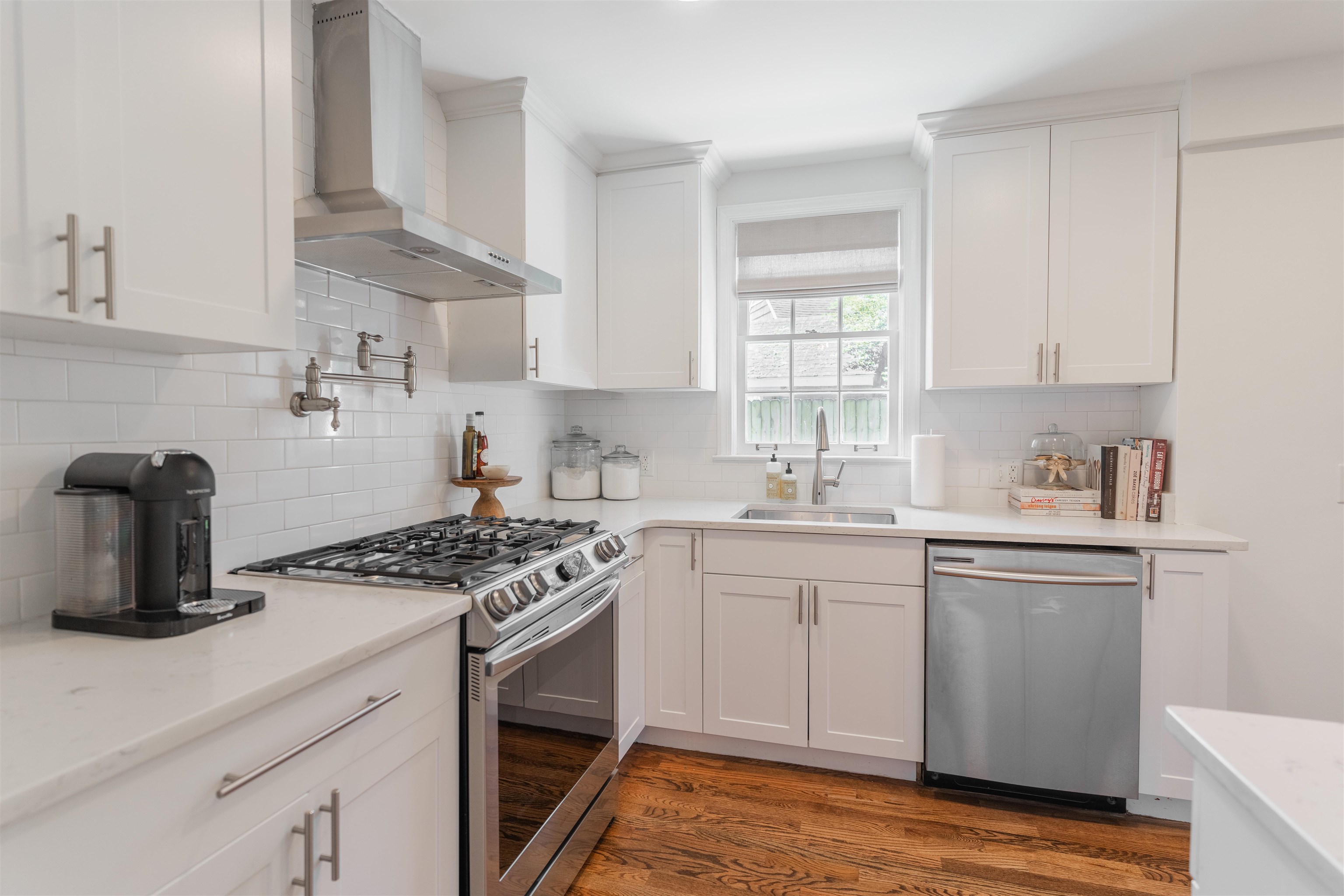 497 East Swan Ridge Circle Memphis, TN 38122 - Photo 7 of 29 Kitchen featuring dark hardwood / wood-style flooring, stainless steel appliances, white cabinetry, and wall chimney range hood