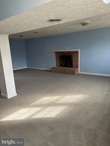 a view of empty room with a fireplace
