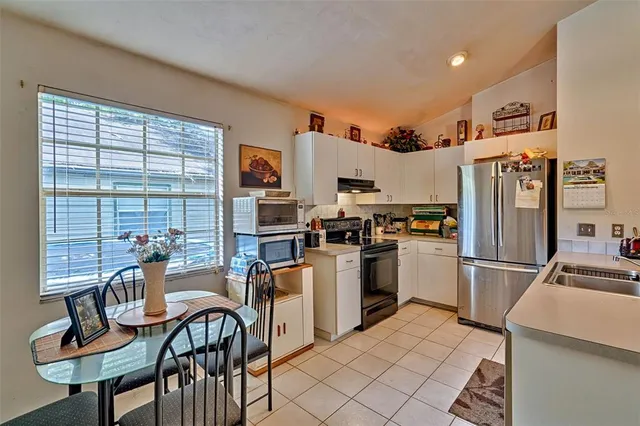 a kitchen with refrigerator and chairs