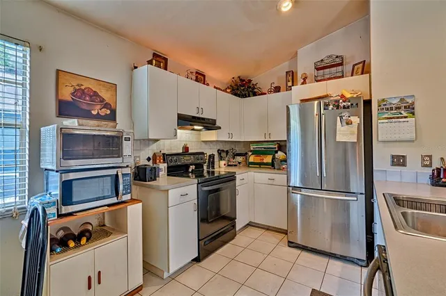 a kitchen with stainless steel appliances granite countertop a refrigerator and a stove top oven