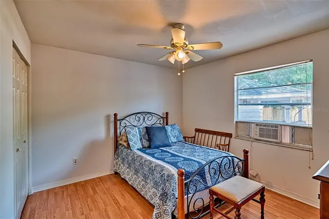 a bedroom with a bed and wooden floor