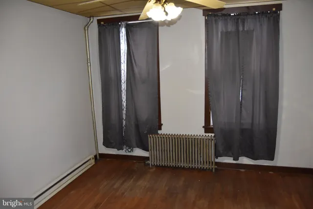 a view of a room with wooden floor and mirror