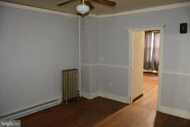 an empty room with wooden floor and closet