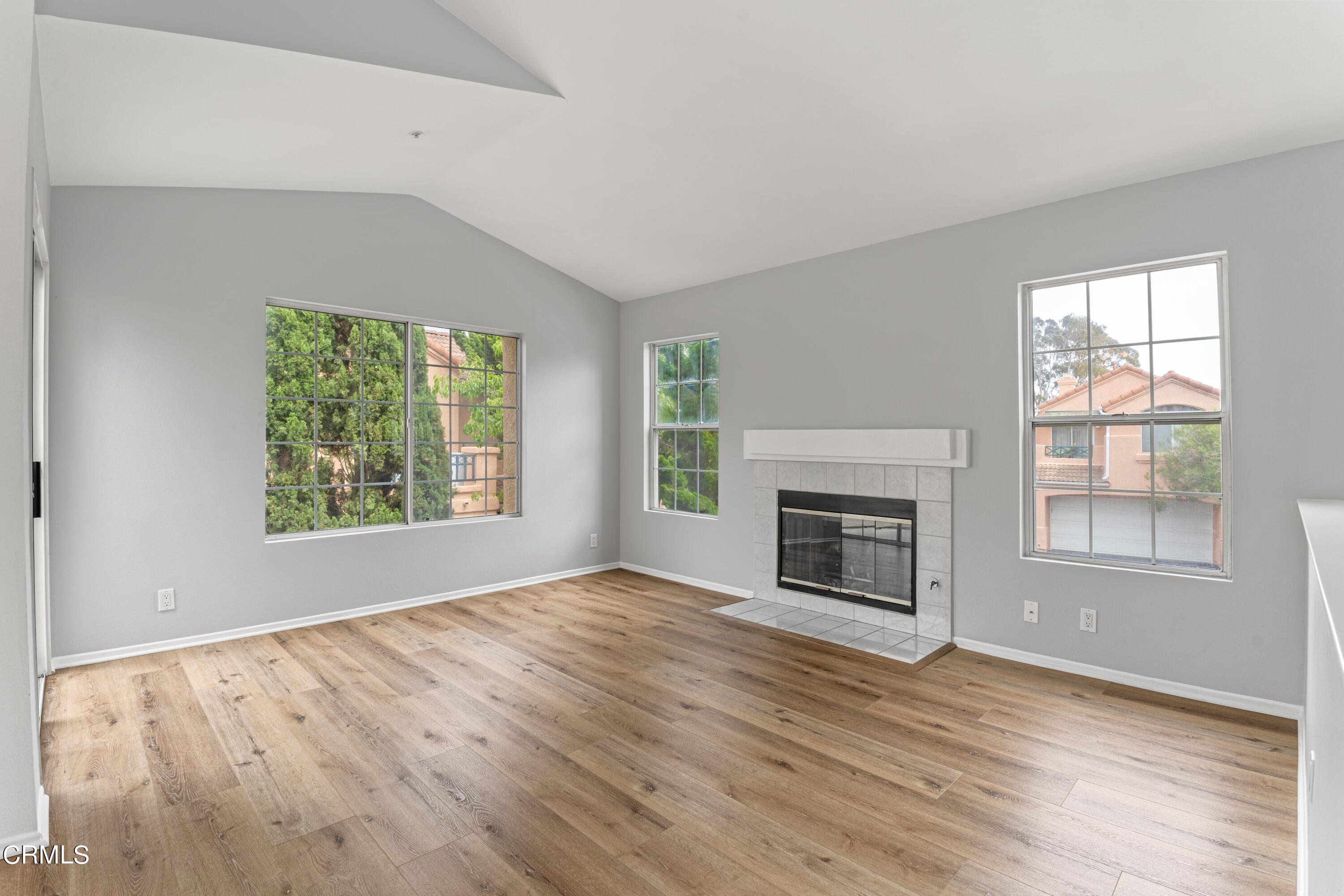 738 Moby Dick Lane Oxnard, CA 93030 - Photo 29 of 48 an empty room with windows a fireplace and wooden floor