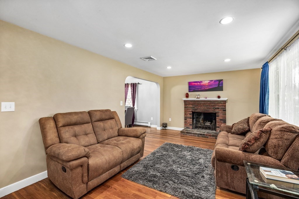 17 Pinetree Road Stoughton, MA 02072 - Photo 11 of 34 a living room with furniture a fireplace and a flat screen tv